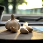 Close-up of fresh garlic cloves on a sunlit wooden table, creating a warm, natural vibe.