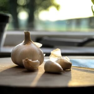 Close-up of fresh garlic cloves on a sunlit wooden table, creating a warm, natural vibe.