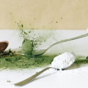 Dynamic close-up of various spices and powders on spoons, emphasizing vibrant colors.